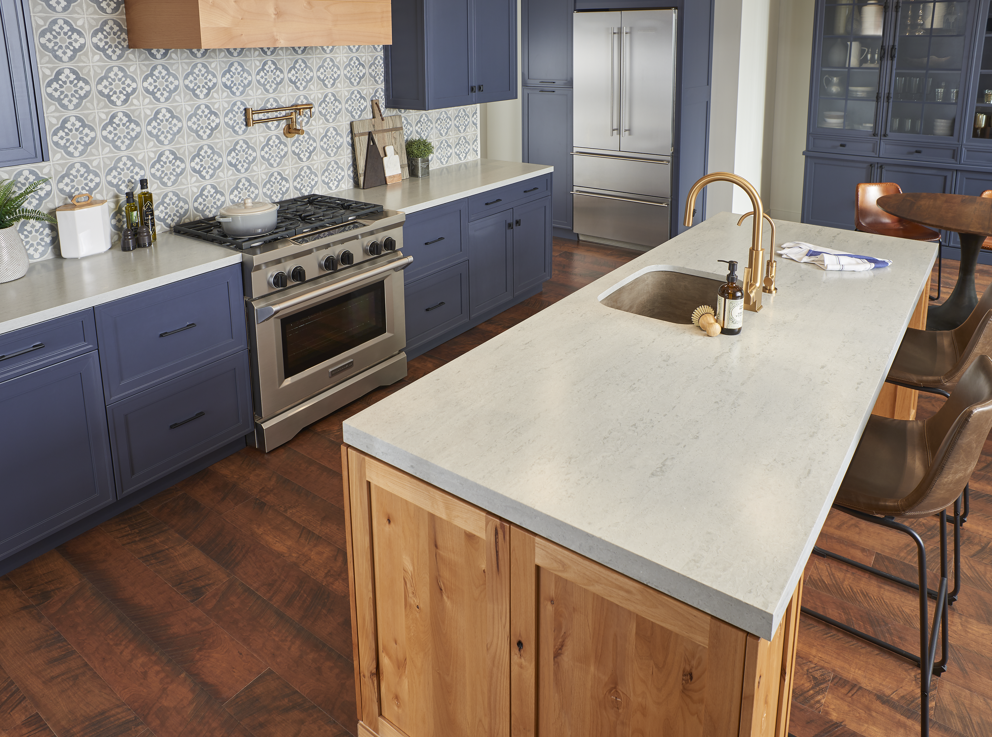 blue kitchen cabinets with solid surface countertops and full height tile backsplash