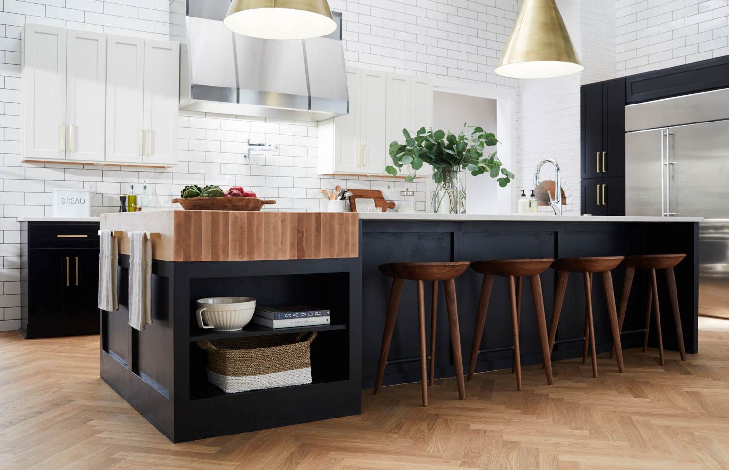 butcher block countertop at the end of the ktichen island with white tile backsplash