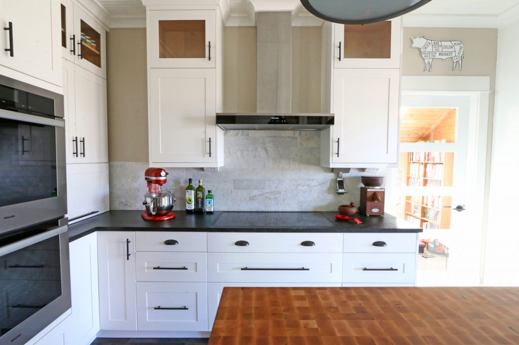 butcher block island in kitchen with dark countertops and white cabinets