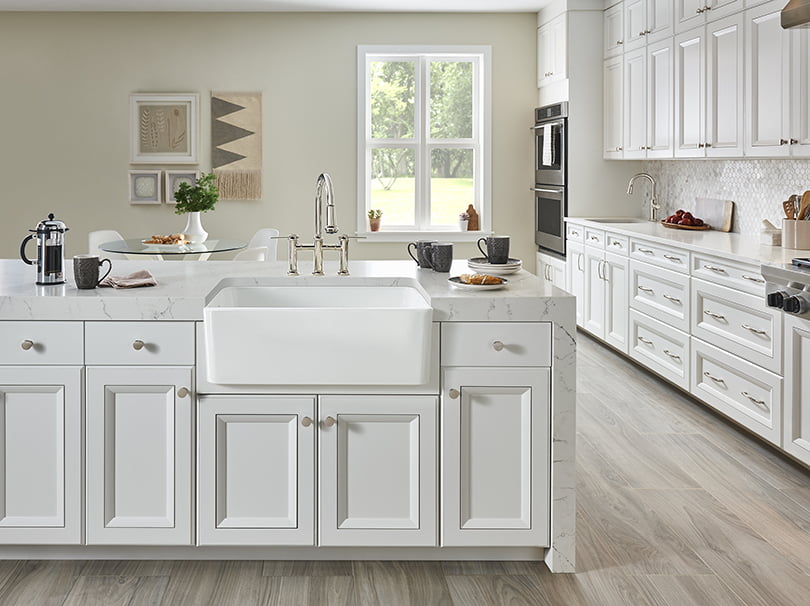 white porcelain farmhouse sink in kitchen island with white cabinets
