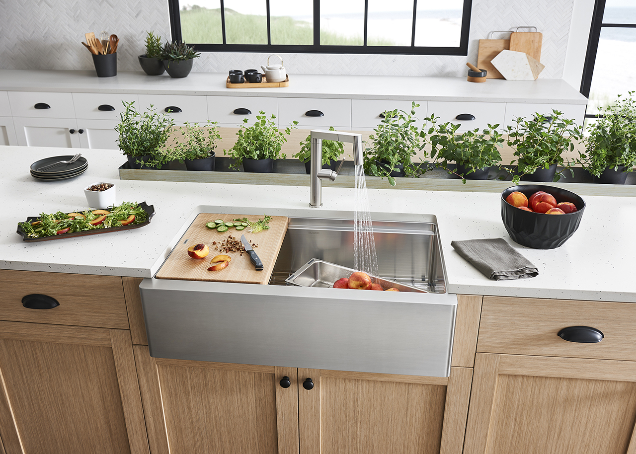 stainless steel farmhouse sink with food and wood cabinets