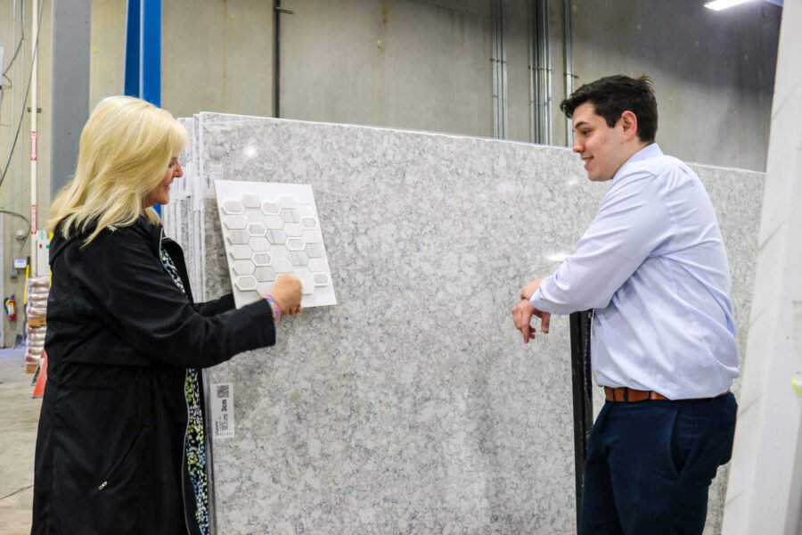 man and woman looking at quartz slab and tile