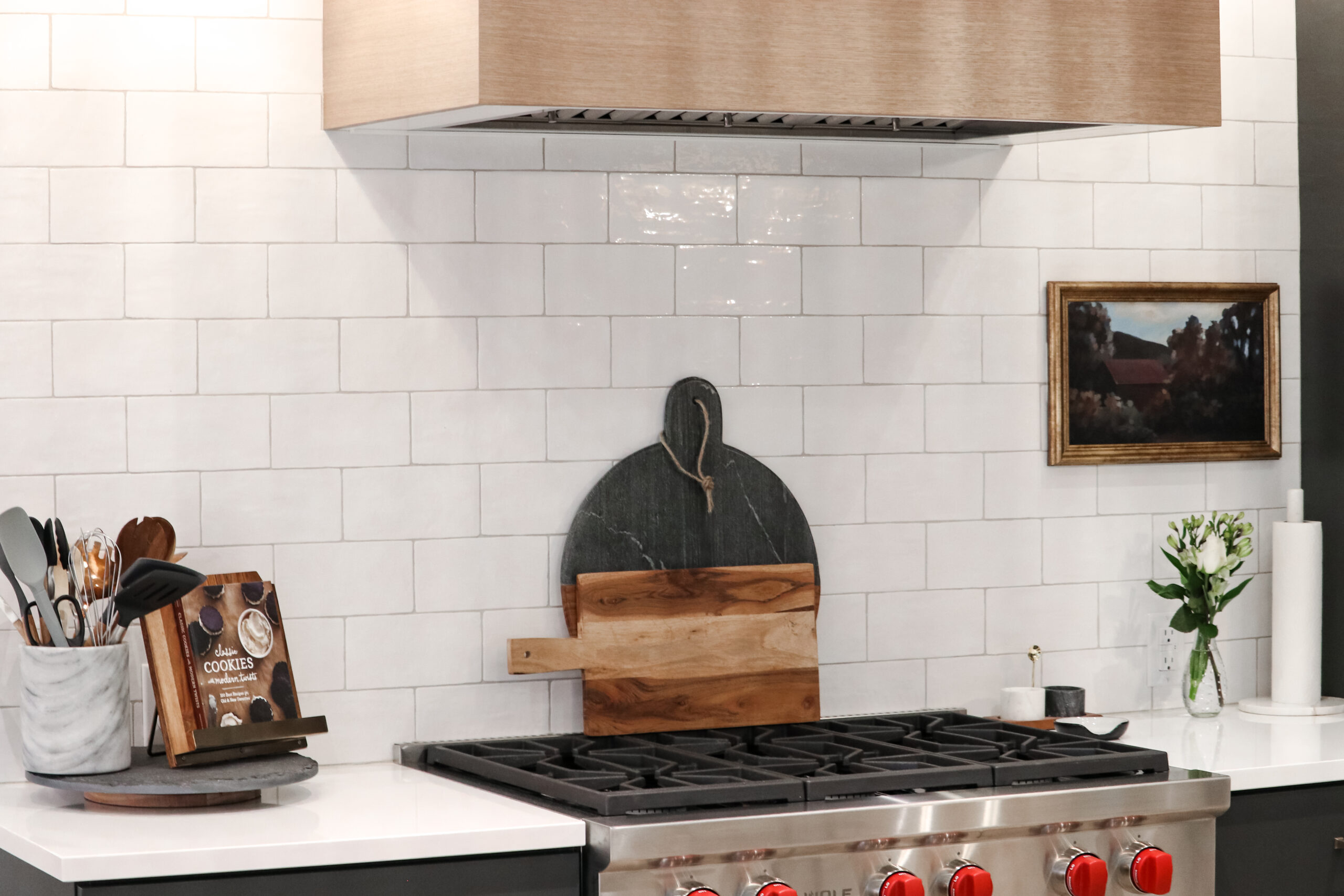 kitchen stove with cutting boards and white subway tile backsplash