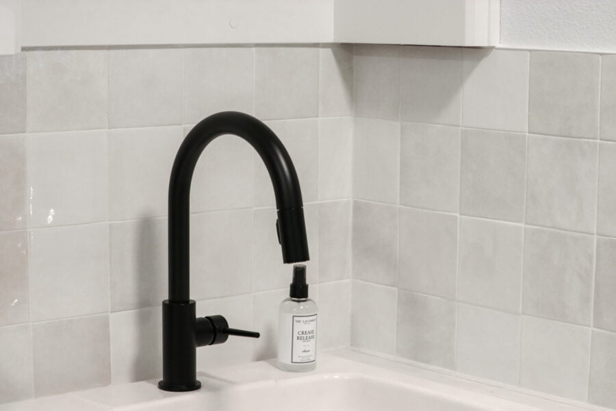 white grout paired with white tile backsplash with a black faucet