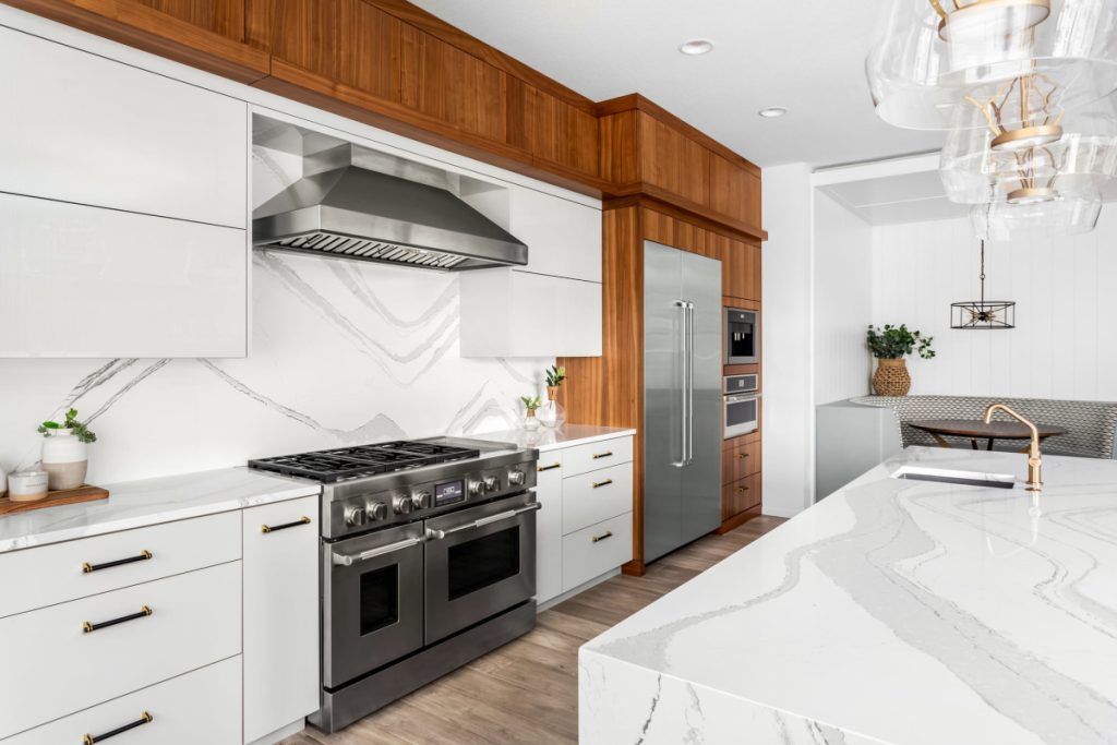 Beautiful kitchen with waterfall quartz island, pendant lights and hardwood floors.