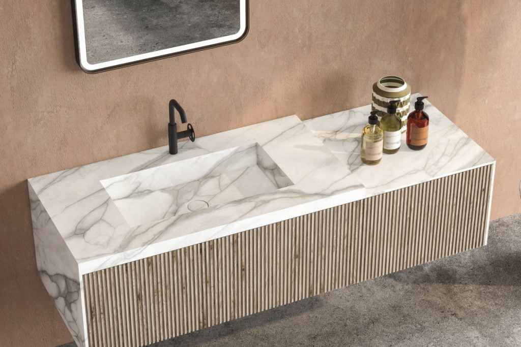 Calacatta marble countertops basin standing on a wooden bathroom furniture.