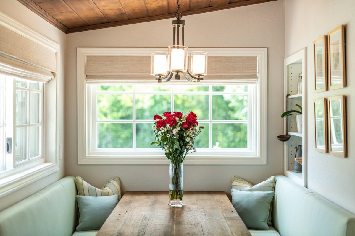 Comfortable kitchen nook with roses on rustic table